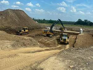 Excavators and earthwork crews grading a construction site